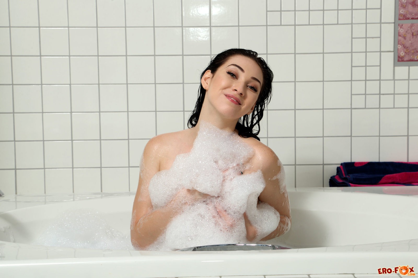 Голая попка девушки в ванной с пеной